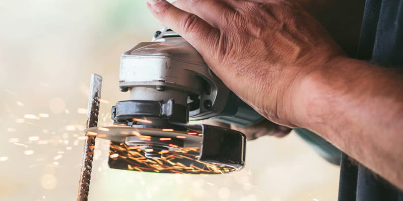 Image of a worker grinding metal representing Woodworking and Metalworking Machinery which are areas of interest to readers of PCBE.