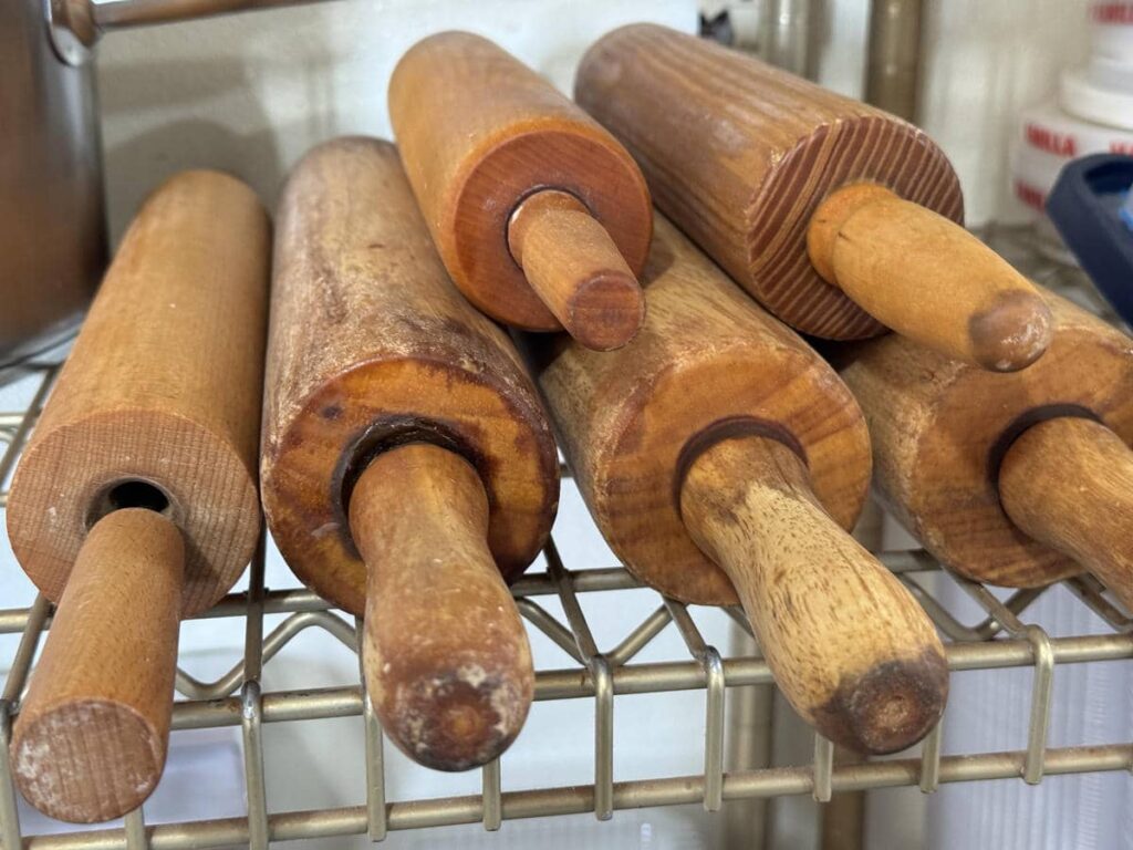 Wooden rolling pins and baking tools used for shaping dough at Country Lane Bakery.
