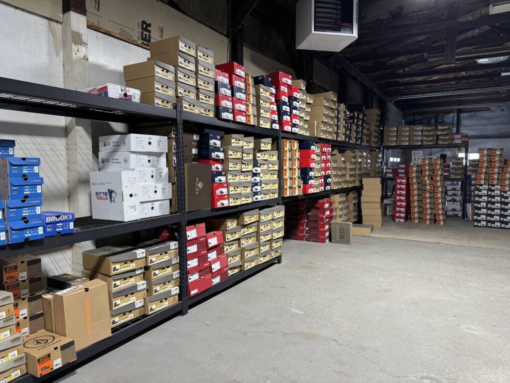 Shelves filled with boxed work shoes in the Midwest Utility Source inventory space